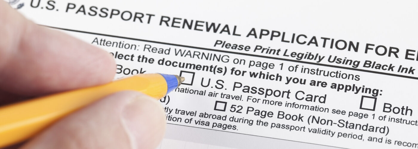 hands pencil filling out passport renewal application