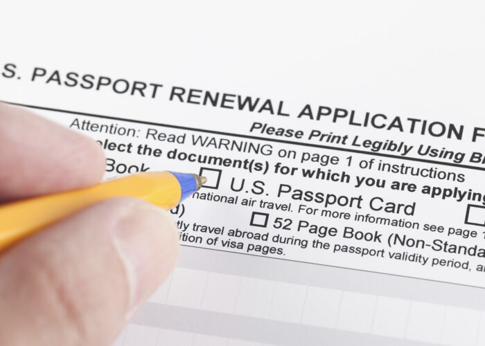 hands pencil filling out passport renewal application