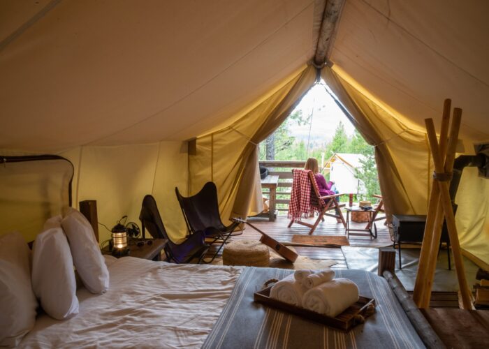 woman-sitting-outside-luxury-tent-on-glamping-trip-in-glacier-national-park