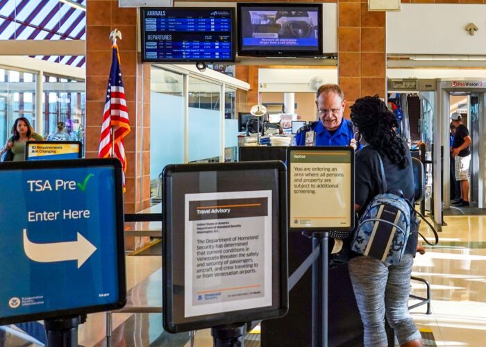 People going through TSA security screening a busy international airport.