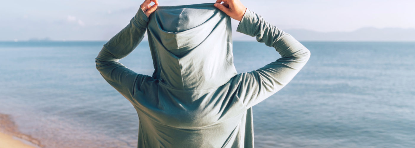 Person wearing a hoodie at the beach