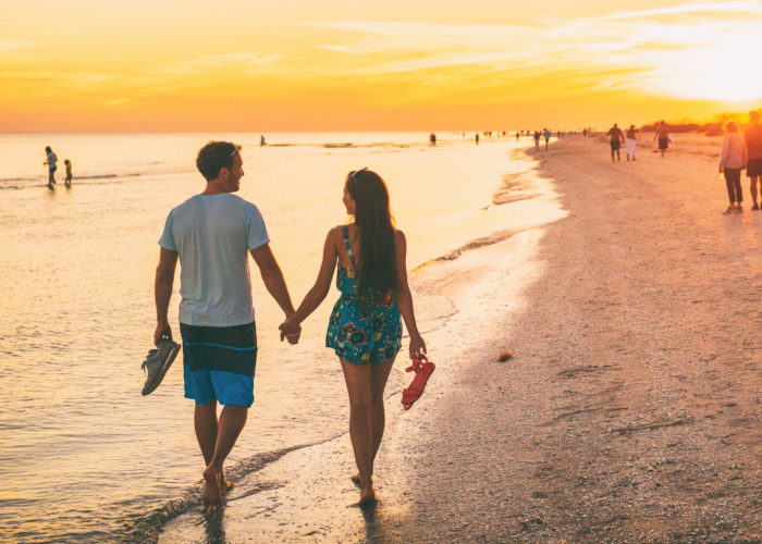 A couple walking along the beach at Sanibel Island, Florida