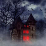 Haunted house on a hill with red lights shining inside and bats flying overhead