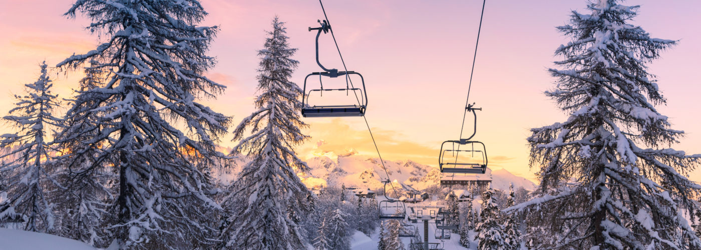 Ski lift on a snowy mountain at sunrise